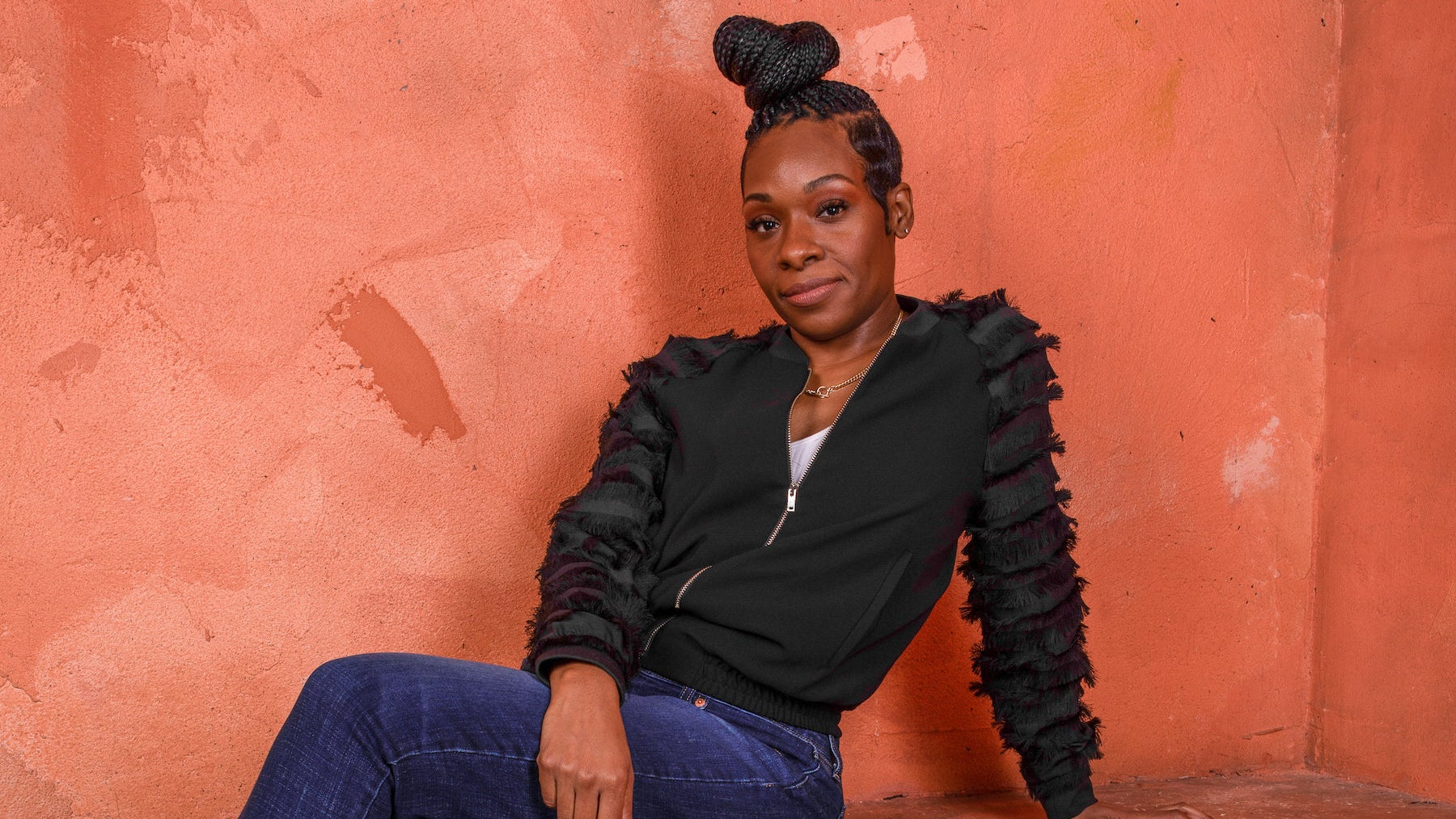 sabine sitting dwon with and orange background